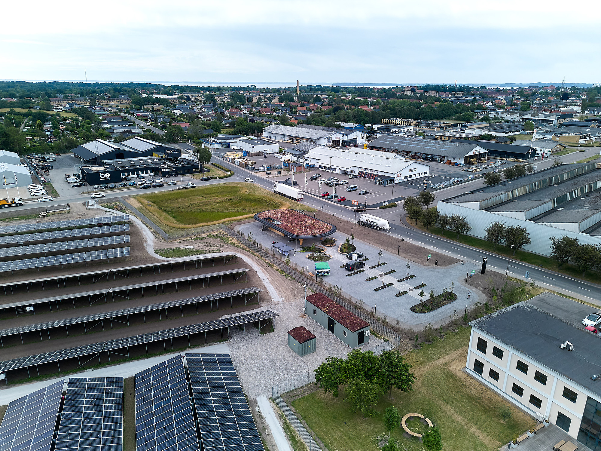 Dronebillede af kontorbygning og solpark)